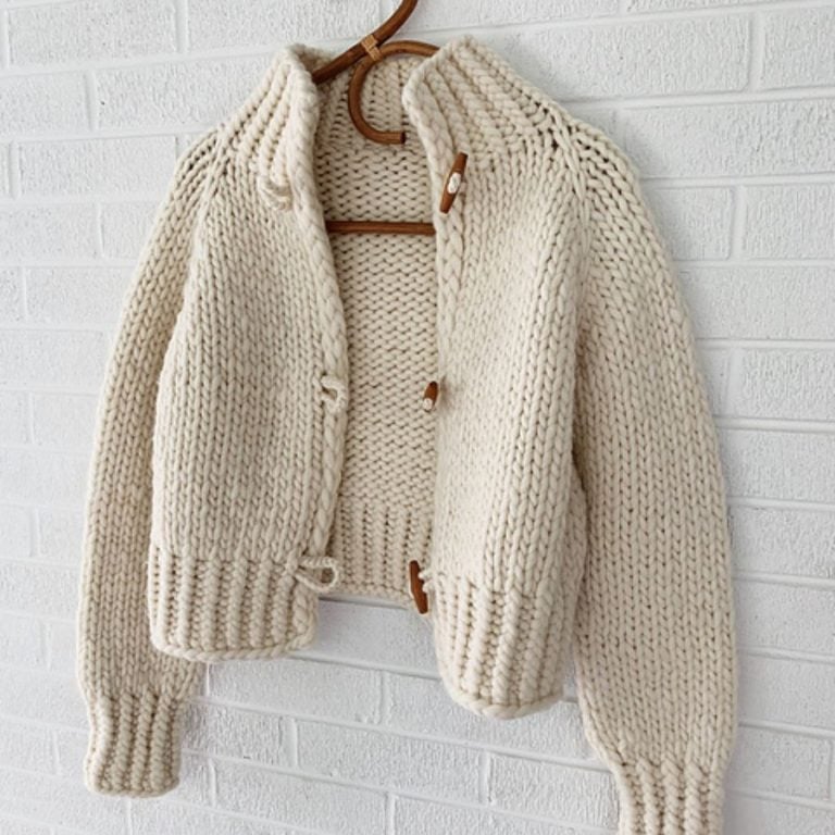 Handgemachte Wollhäkeljacke in Cremefarbe, warm und stylisch.