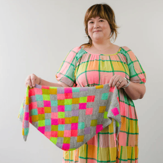 Frau zeigt bunten gehäkelten Schal, DIY-Kultur, Handarbeit, kreative Mode.
