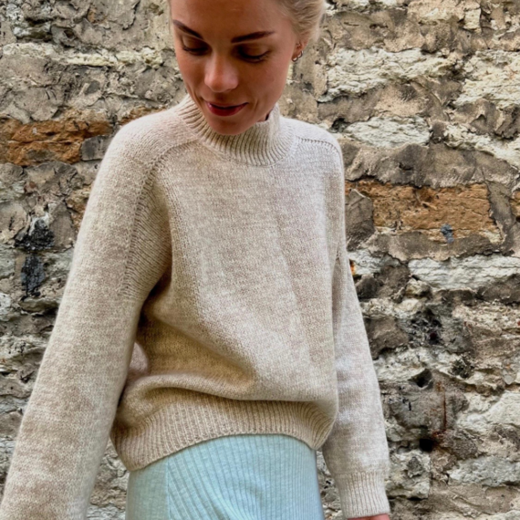 Junge Frau trägt ALL FALL Sweater von Casual Knits Studio, einen cremefarbenen sanften gestrickten Pullover